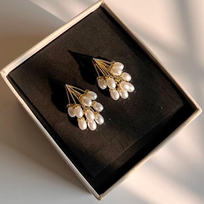 Pearl earrings in a black box on a light background