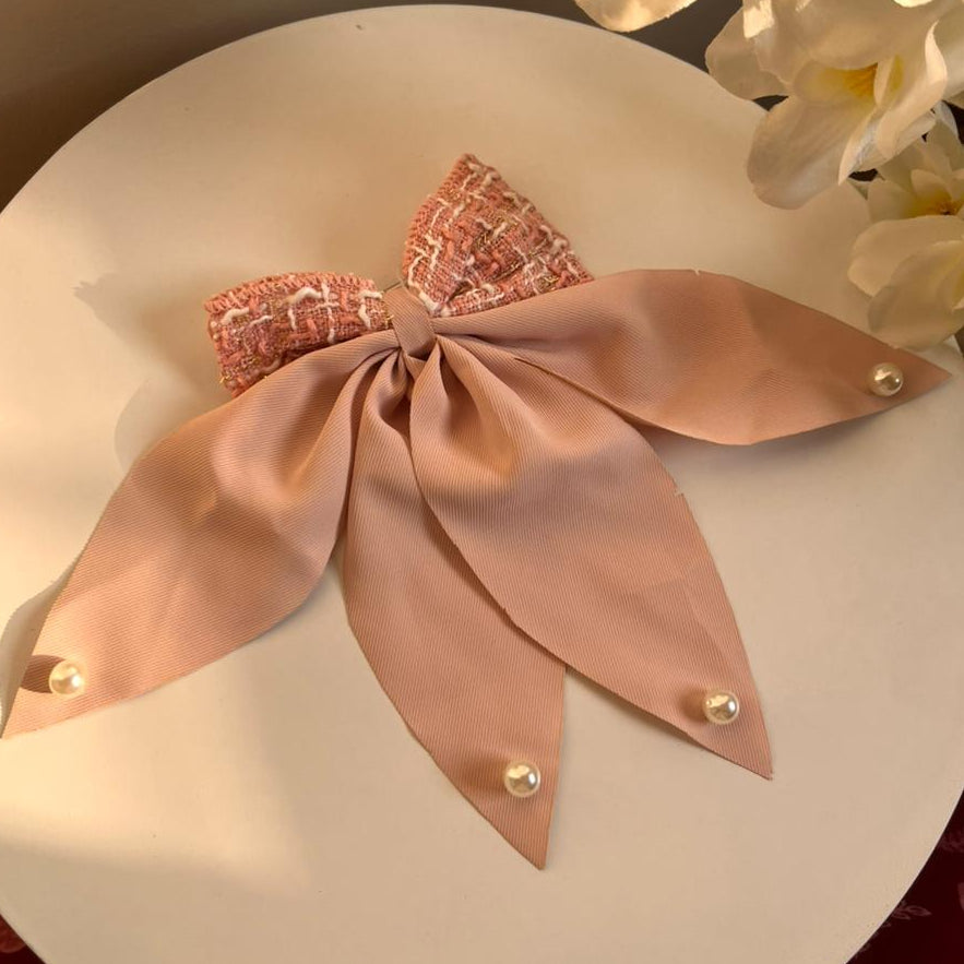 Decorative headband with a bow on a white plate with flowers in the background