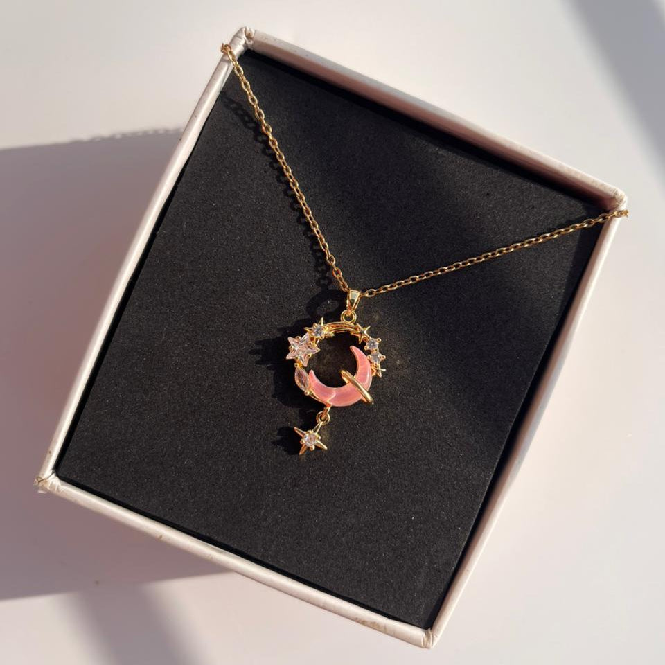 Necklace with a moon and star pendant in a box on a white surface