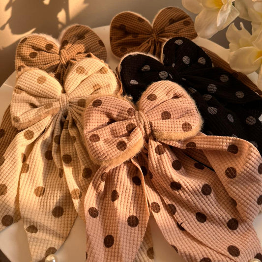 Set of decorative bows with polka dot patterns on a light background