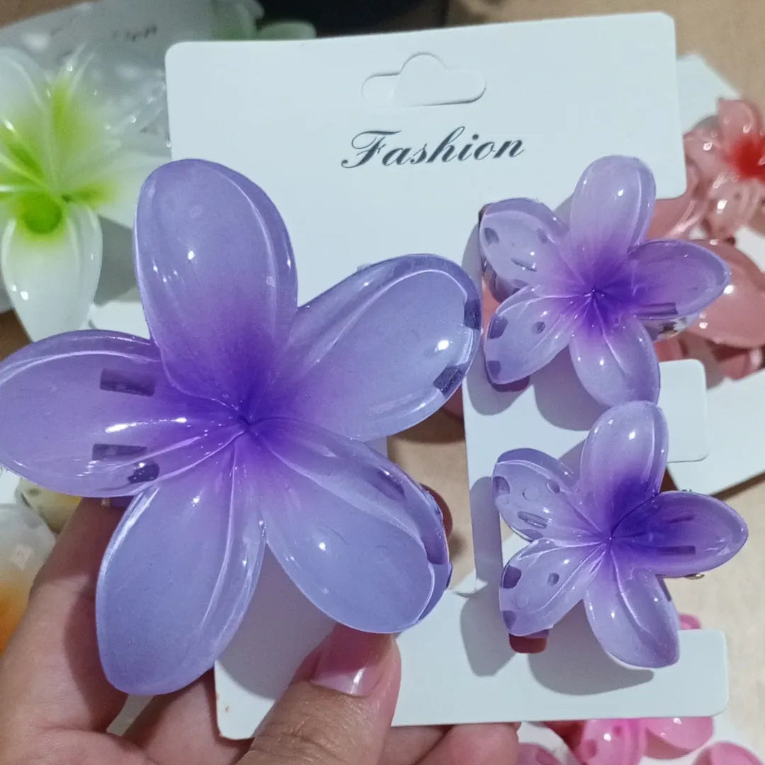 Purple flower-shaped hair clips on a white card with 'Fashion' text, held by a hand.