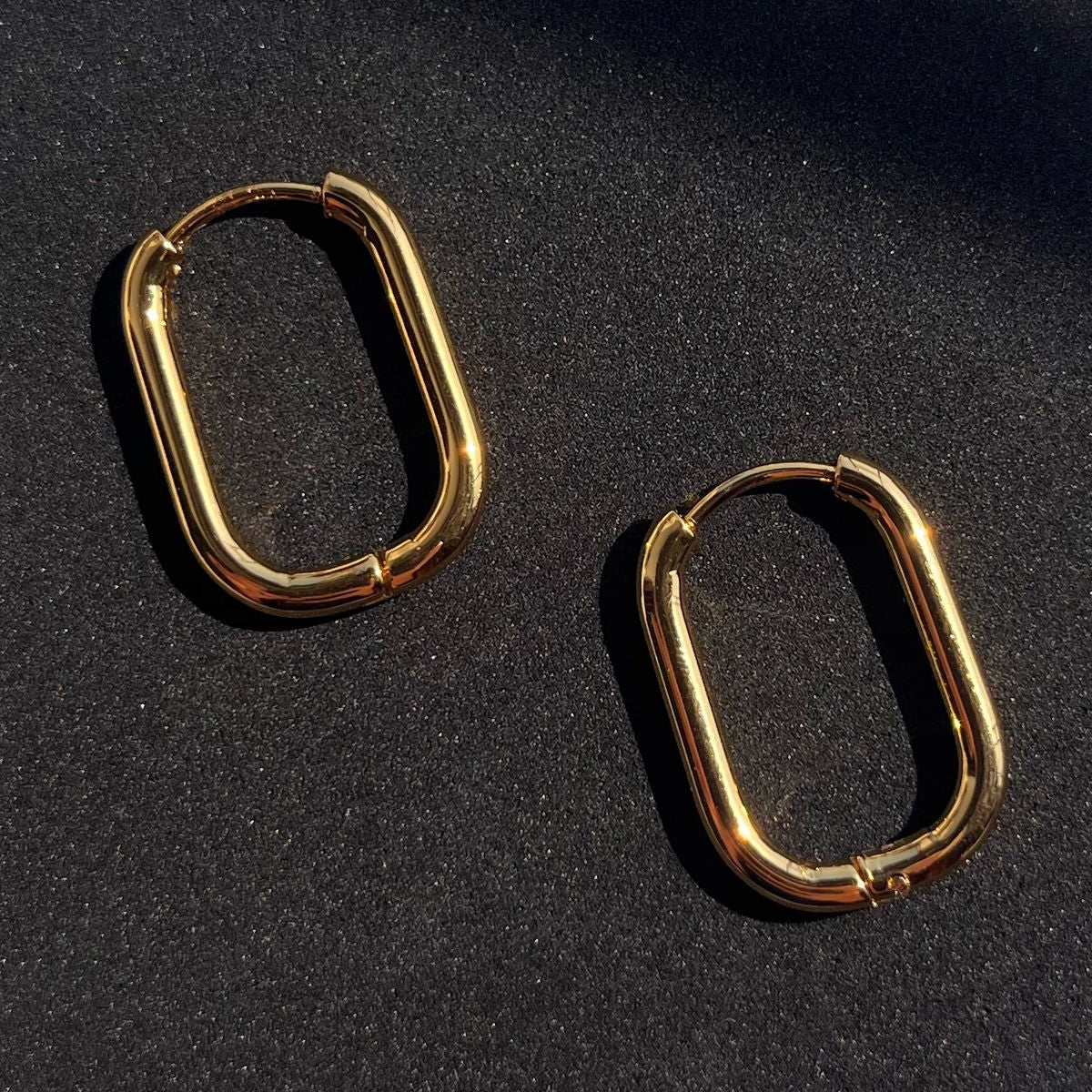 Gold hoop earrings on a black background