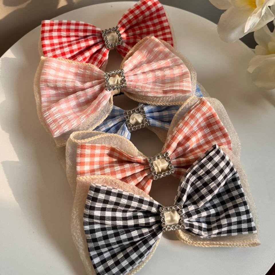 Set of decorative bows with checkered patterns on a white plate.