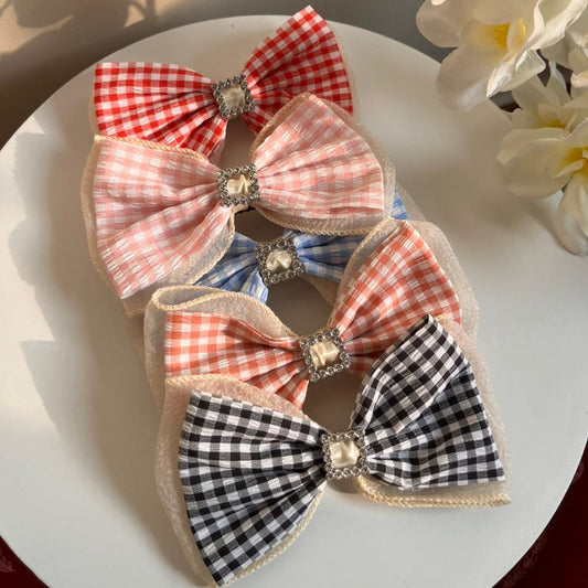 Set of decorative bows with checkered patterns on a white surface.