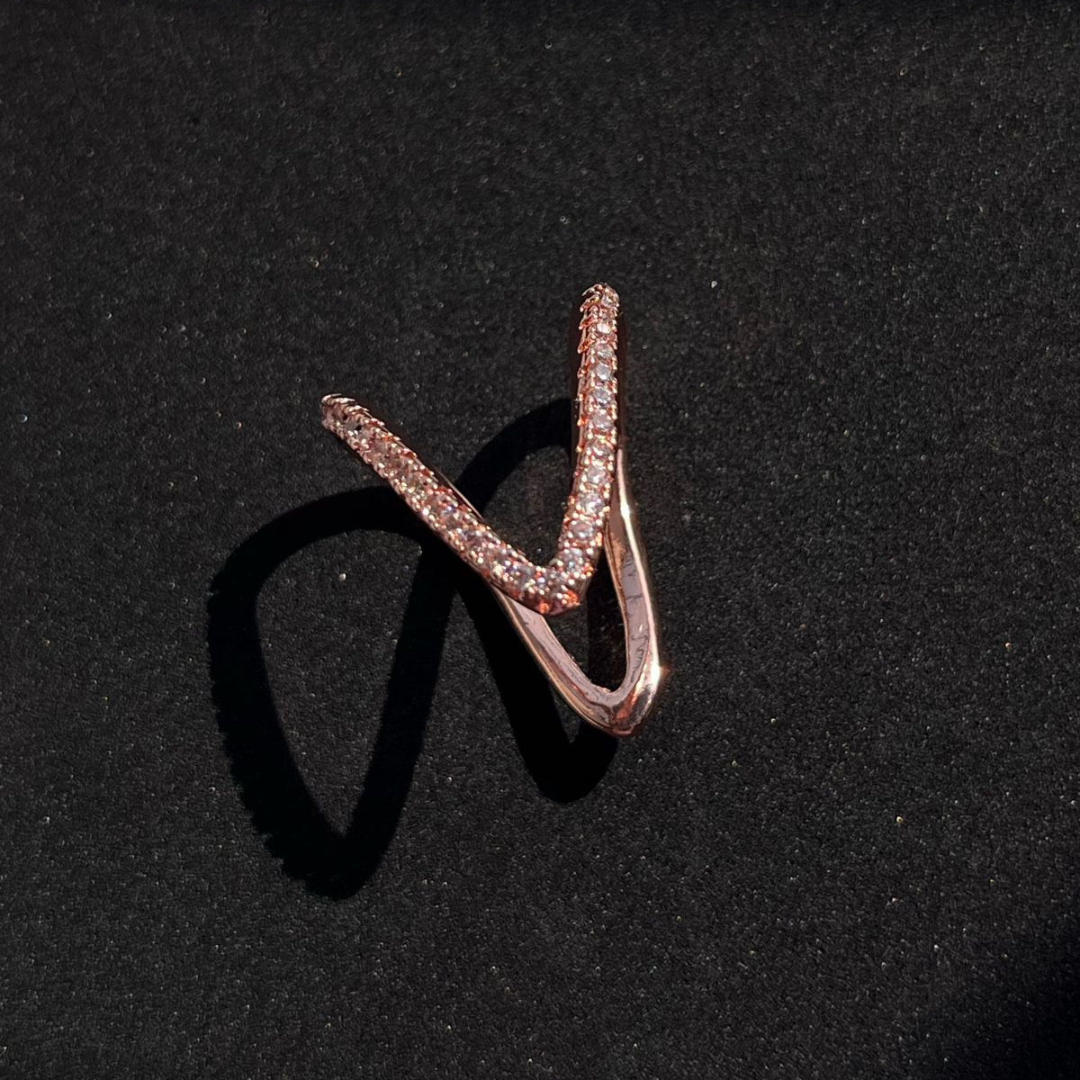Rose gold ring with embedded stones on a black background