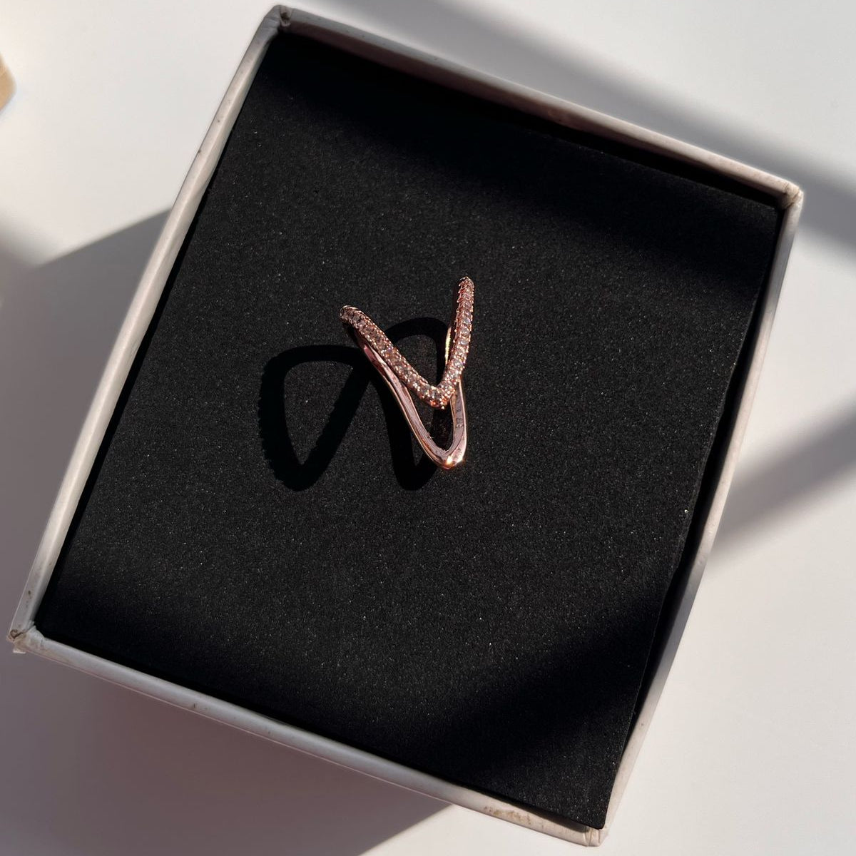 Rose gold ring in a black box on a light surface