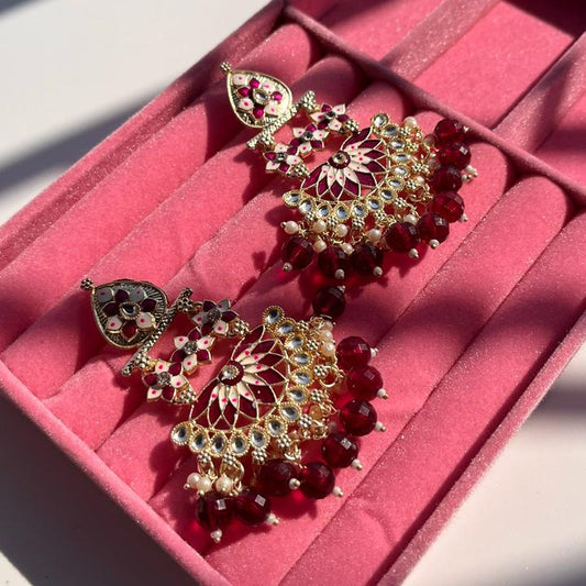 Ornate earrings on a pink jewelry box