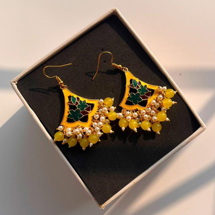 Decorative earrings in a box on a light background