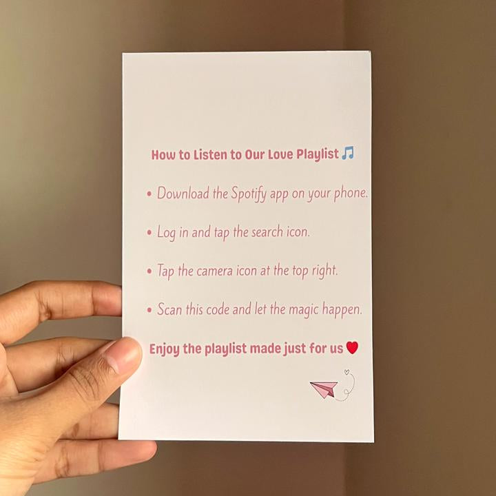 Hand holding a white card with red text against a brown background