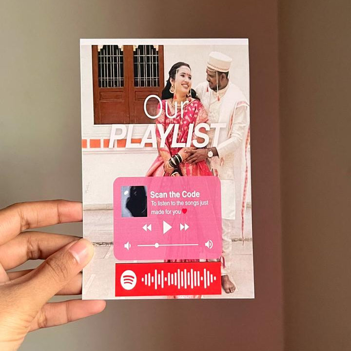 Hand holding a promotional flyer for 'Our Playlist' with a couple and music player graphic on a plain background.