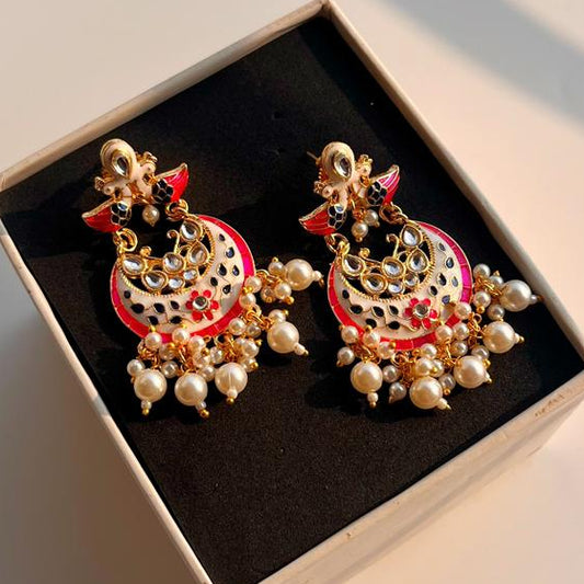Decorative meenakari earrings in a box on a light surface