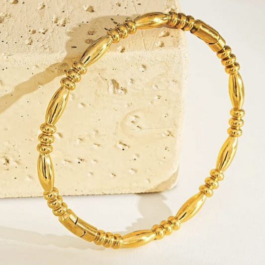Gold bracelet on a textured stone surface