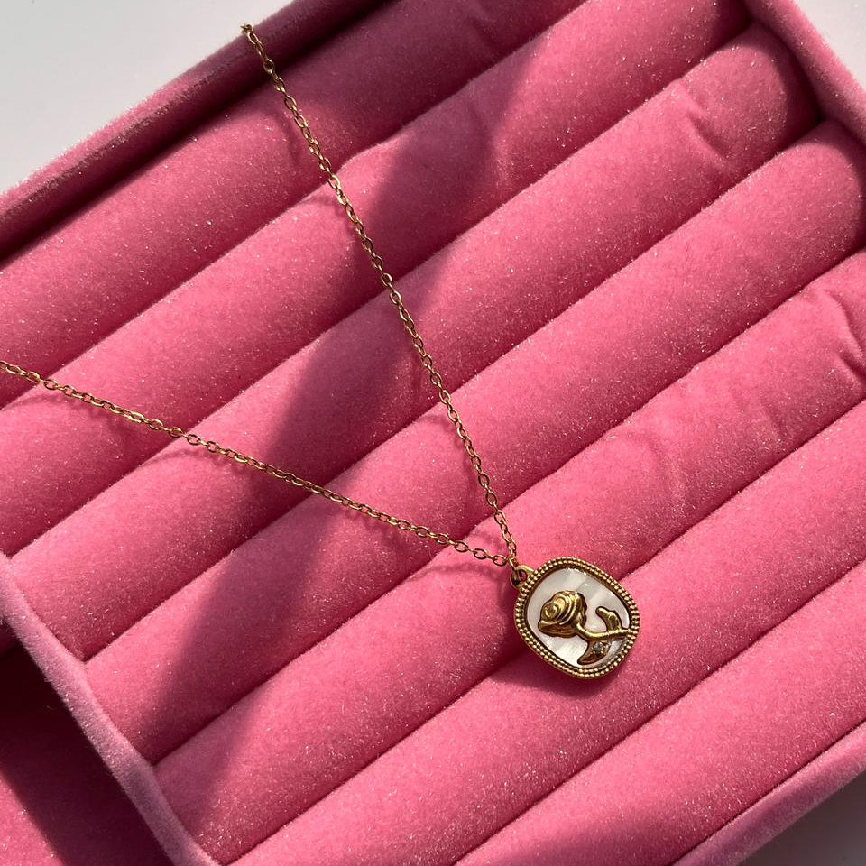 Necklace with a pendant on a pink velvet surface
