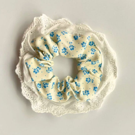 Scrunchie with blue floral pattern on a white lace background