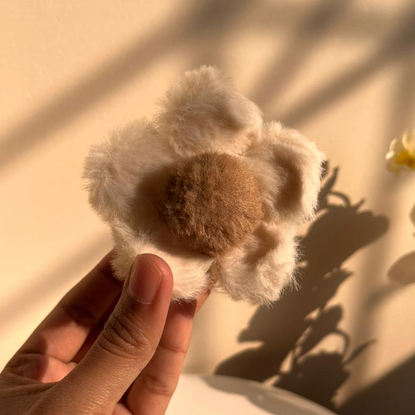 Hair clip held by a hand against a neutral background