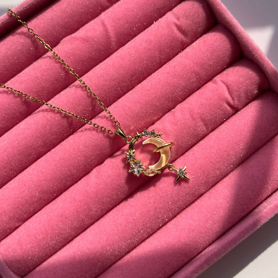Gold necklace with a pendant on pink velvet in a jewelry box